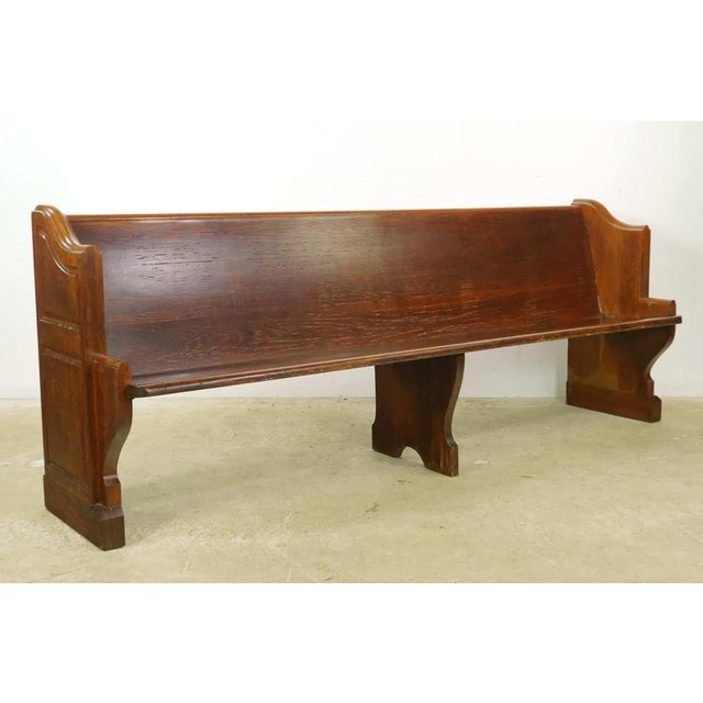 Reclaimed church pew bench made of oak with a dark tone finish, with traditional recessed carvings on each side. The bench...