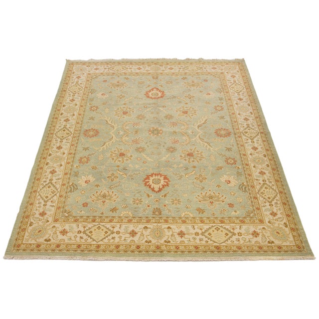 This stunning handmade Peshawar wool rug features a light green field adorned with gold and rust accents throughout its...