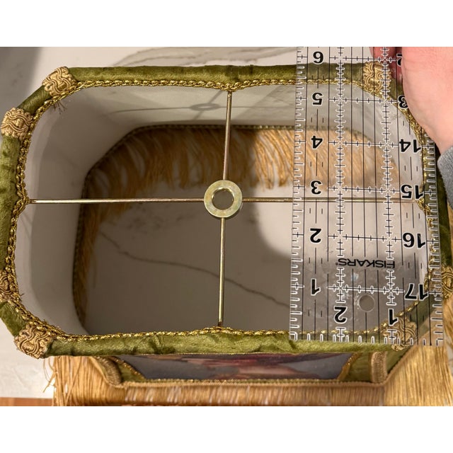 A richly layered custom lampshade crafted in textured olive green velvet and finished with ornate gold trim and luxurious...