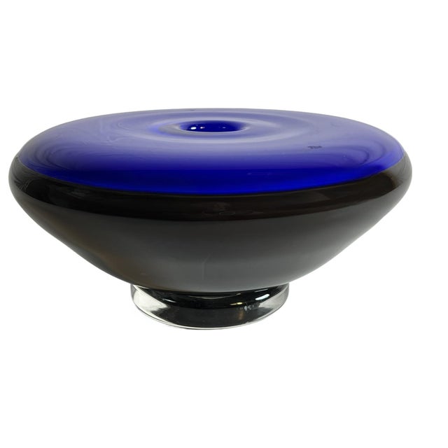 This art glass piece is a Postmodern Iridescent Black and Cornflower Blue Cased Glass Vase, most likely Murano style and...