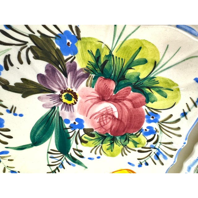 A vibrant set of six vintage hand painted ceramic dessert plates featuring lively floral bouquets in saturated hues of...