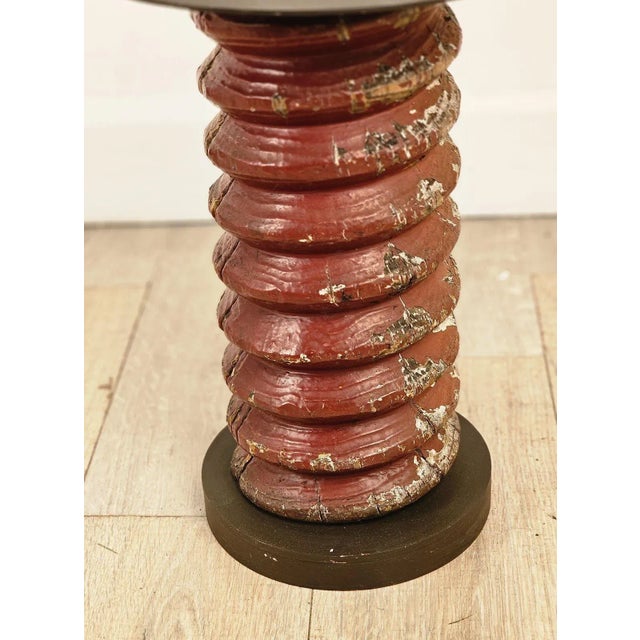 An antique wooden corkscrew, now a table.