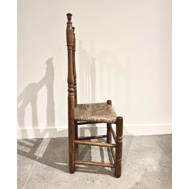 Wood frame with banister back and cutout heart detail in bonnet. Caining on seats. Original materials.