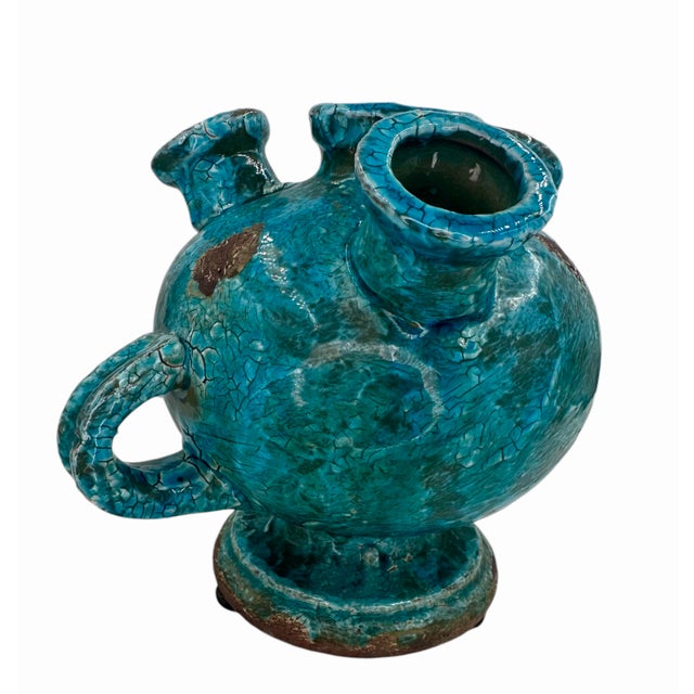 This striking glazed terracotta jar/vase combines a brutalist silhouette with a vibrant cerulean or turquoise blue hue....