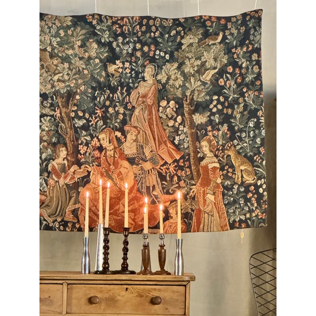 A large French tapestry by Tapisseries du Lion, depicting an elaborate medieval courtly garden scene filled with richly...