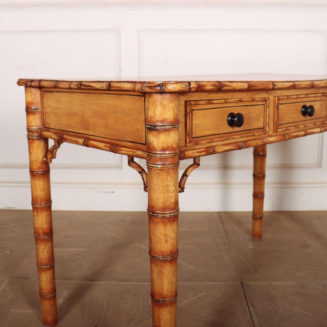 Early 20th century English three drawer faux bamboo pine desk. 1920. Clearance under rail: 24.5-inches (62cm) This piece...