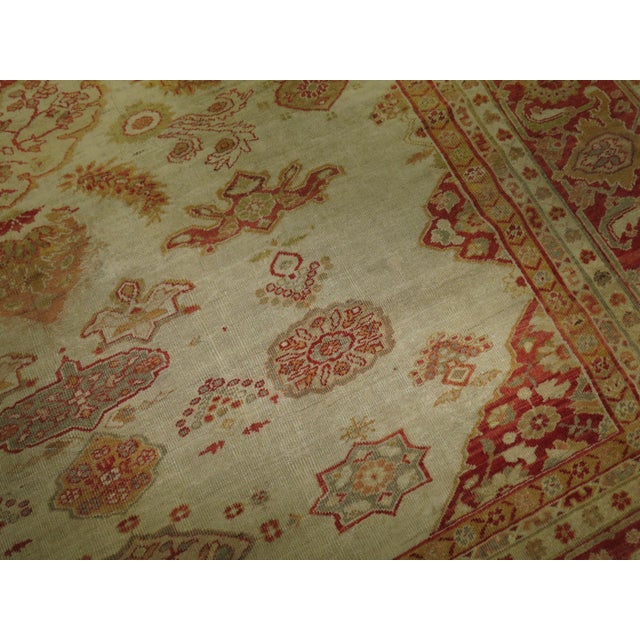 A connoisseur caliber early 20th century room size Persian Sultanabad carpet with red and orange accents on an ivory field...
