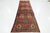This vintage Persian wool rug features a red field with a multicolor allover pattern. This rug measures 3'4'' x 13'.