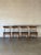 This set of four dining chairs features gently curved solid teak backrests and clean tapered legs. Black upholstery...