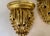 Pair of late 20th century Hollywood Regency wall shelves in a gold finish. Feature a romantic draped fabric look. Please...