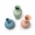 Sculptural set of three Middle Kingdom porcelain vases in soft pastel pink, celadon green, and blue. Each features a...