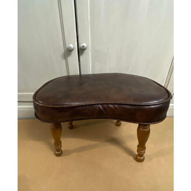 Fabulous vintage footstool; kidney shaped in thick brown pleather with wood legs. The dimensions are: 12"" high 17.5""...