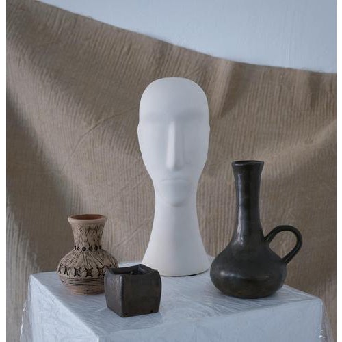 Mid-century plaster head sculpture inspired by ancient Cycladic art. The elongated proportions, simplified facial planes,...