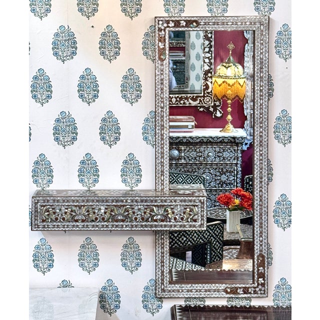 An elegant Syrian mother-of-pearl inlaid wall mirror with shelf, handcrafted from solid natural walnut wood and genuine...