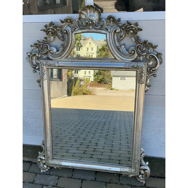 Beautiful large hand carved and silver gilt vintage mirror in Rococo style. Top mirrored part is intentionally distressed.