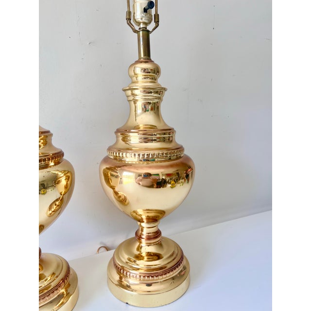 Beautiful pair of vintage lacquered brass table lamps with beaded details. The round center brightens a space with its...