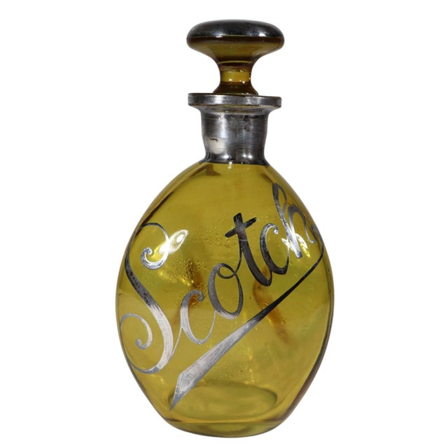 Voguish Art Deco pinch sided amber glass decanter with silver overlay lettering. Circa 1930's made in the USA this example...
