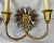 Pair of gilt two light sconces each with a mirrored 12 point starburst. The gilt finish and mirrored appointments give...