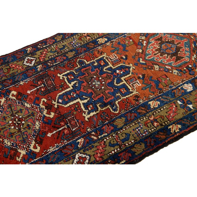 This stunning 20th-century Persian Heriz handmade wool rug showcases a rich orange-rust color field, beautifully accented...