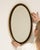 This mirror makes its impression through black frame with gold inner edge, oval. Dating to Early 20th Century and...
