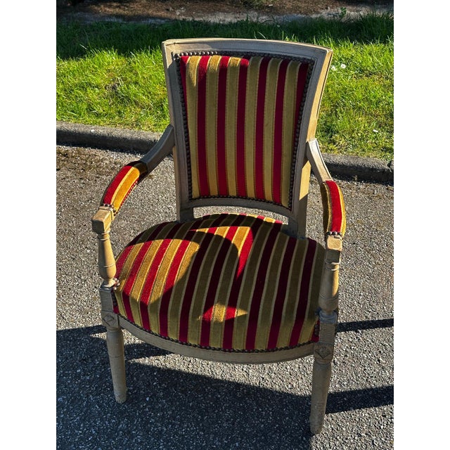 Louis XVI style cabriolet armchair in carved and patinated wood. This model features a rounded backrest resting on tapered...