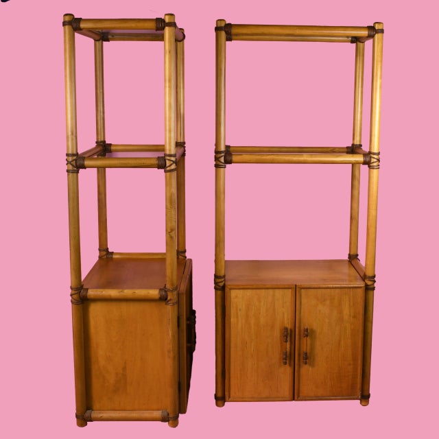 A pair of rattan etageres with tall open shelving for books, barware, plants and collected objects. The airy woven frames...