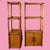 A pair of rattan etageres with tall open shelving for books, barware, plants and collected objects. The airy woven frames...