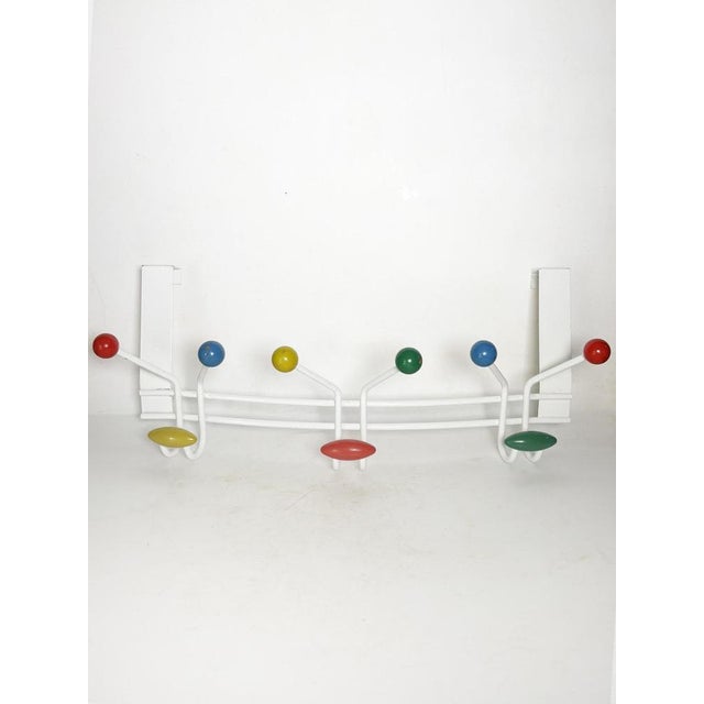 Wall-mounted coat rack in white metal and colored wood, made in France in the 1970s. This vintage coat rack charms with...