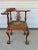 Chippendale style mahogany corner chair with needlepoint seat. The chair has a pierced splat, acanthus carved knee, and...