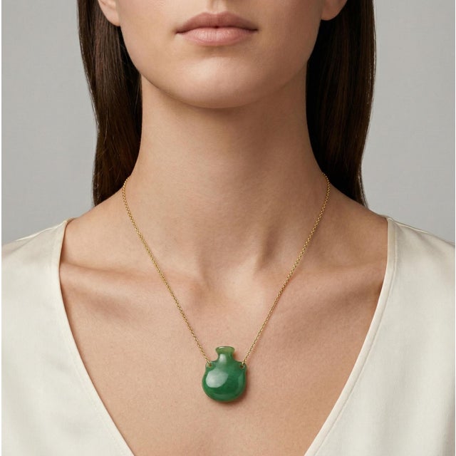 Enhance your collection with this striking vintage 18K yellow gold necklace, from 1970's. Featuring a Bottle shape green...