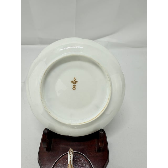 An exquisite example of 19th-century French porcelain artistry, this luxurious cup and saucer set bears the mark of the...