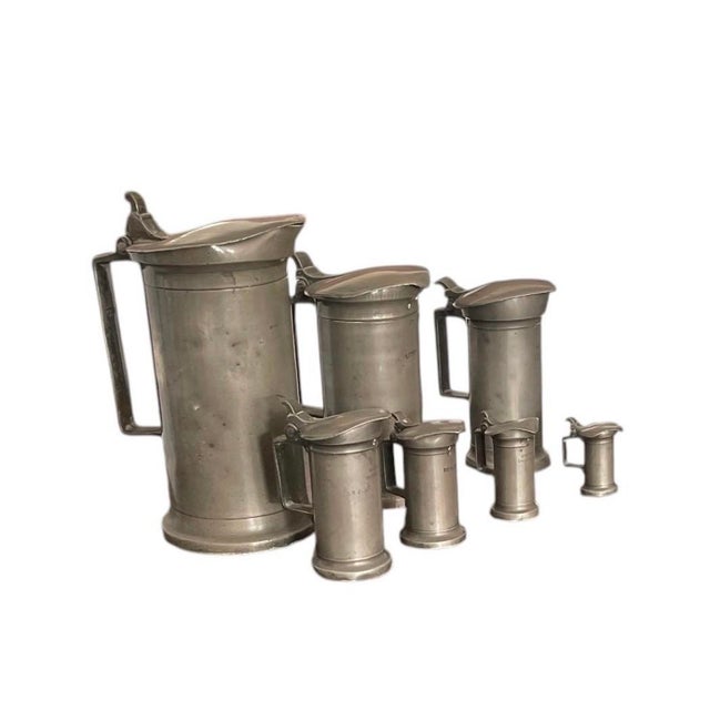 An exceptional and complete graduated set of seven antique French pewter measuring flagons (mesures de capacité), dating...