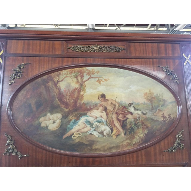 Large French Mirror with brass accents and handpainted scene. Mirror is beveled and in very good condition. The frame is...