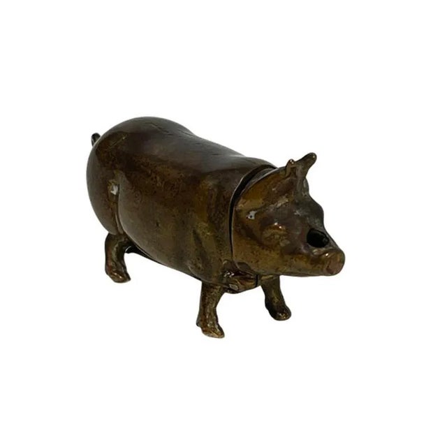 A brass vesta match case in the shape of a pig A small vesta match case in brass. The small pig has a head that comes down...