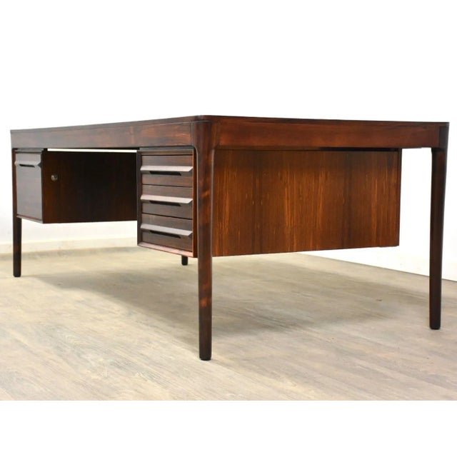 A large mid century modern rosewood executive desk designed by Haug Snekkeri for Bruksbo. This desk offers hanging file...