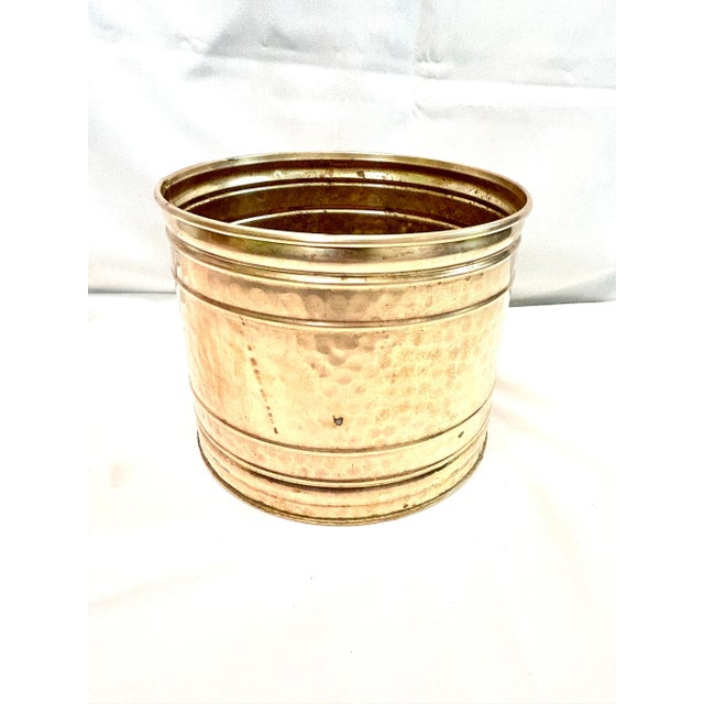 A classic vintage hammered brass cachepot featuring warm golden patina and hand-hammered texture. Pieces like this are...