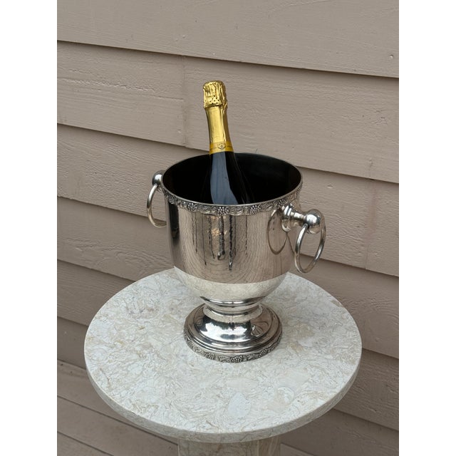 Presenting a vintage ice bucket / champagne chiller in a traditional design with grape leaf motif around its upper edge....