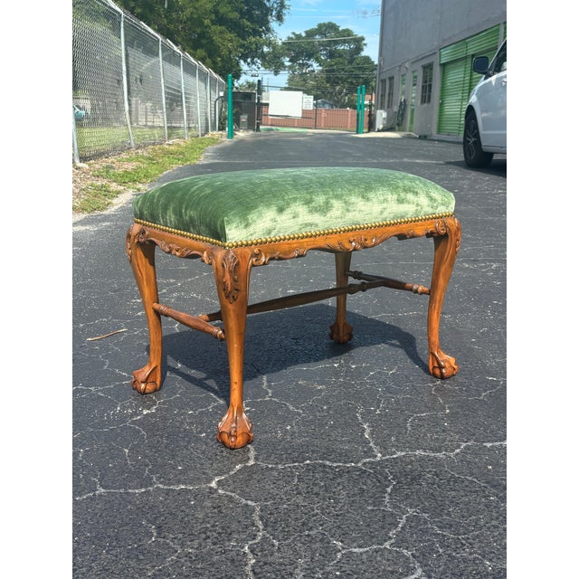 An elegant early 20th-century walnut bench executed in the Queen Anne taste, featuring graceful cabriole legs terminating...