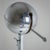 Metal floor lamp with a spherical shade featuring decorative rivet details. The shade features a swivel arm, allowing the...