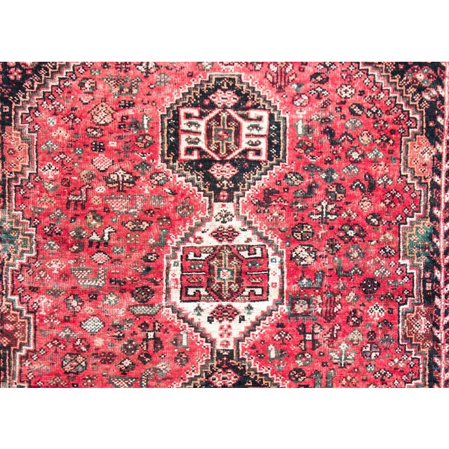 A gorgeous mid-20th century Persian Shiraz rug with a stunning pattern with three large stylized floral medallions living...