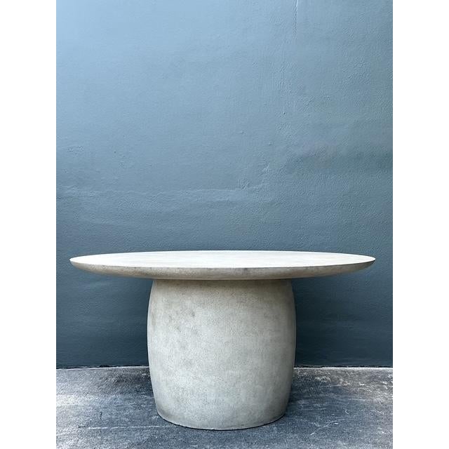 This striking 60-inch round dining table is a masterclass in Postmodern Minimalism, featuring a bold, Brutalist-inspired...