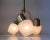 A round brass ceiling light with three dotted opaline glass shades. It features organic shapes and curves and was...