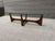 MCM Coffee table featuring a wood base and a clear glass top. The design includes intersecting wooden supports and an...
