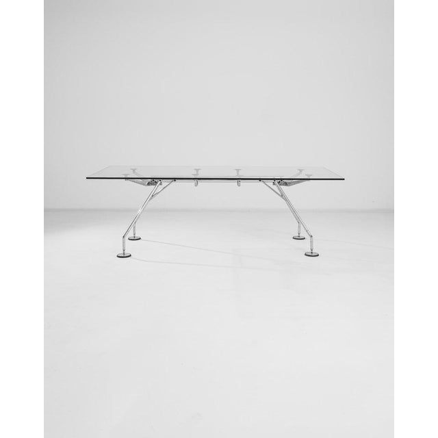 Made in Italy, this metal and glass table was imagined by designer and architect, Norman Foster, a premiere force in high-...