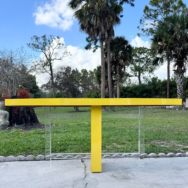 A bold and sculptural Postmodern console table featuring a vibrant high-gloss yellow laminate top that immediately...