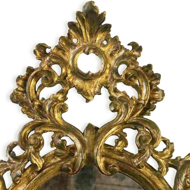 Pair of carved wooden mirrors with a Mecca gilt finish, originally designed as sconces. They have a mercury mirror (one of...
