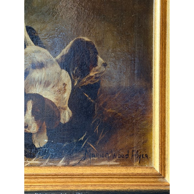A charming early 20th century oil on canvas depicting a playful litter of spaniel puppies gathered in a woven basket...
