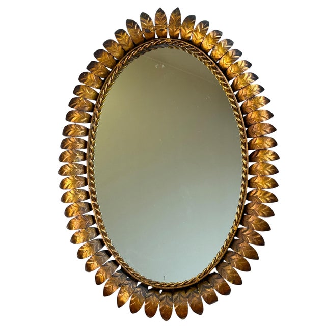Large oval wrought iron sunburst mirror from the 1950s. Italian handcrafted, decorated with leaves.