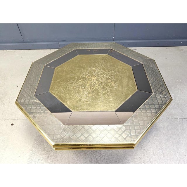 Impressive coffee table by Rodolfo Dubarry. The table is made of wood covered with hammered brass sheets and pewter...