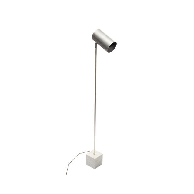 An OMI floor lamp by Koch & Lowy. This vintage lamp features a cylindrical silver tone shade, a slender chrome stem, and a...